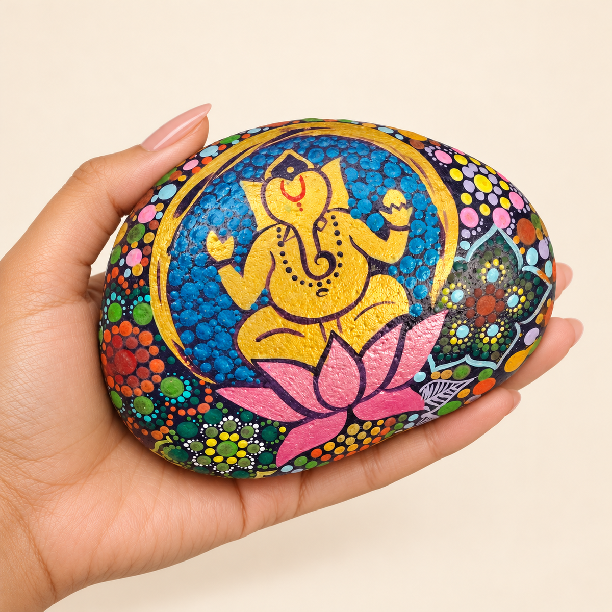 Ganesh: Lotus Celebration hand-painted natural pebble art, shown in hand for scale