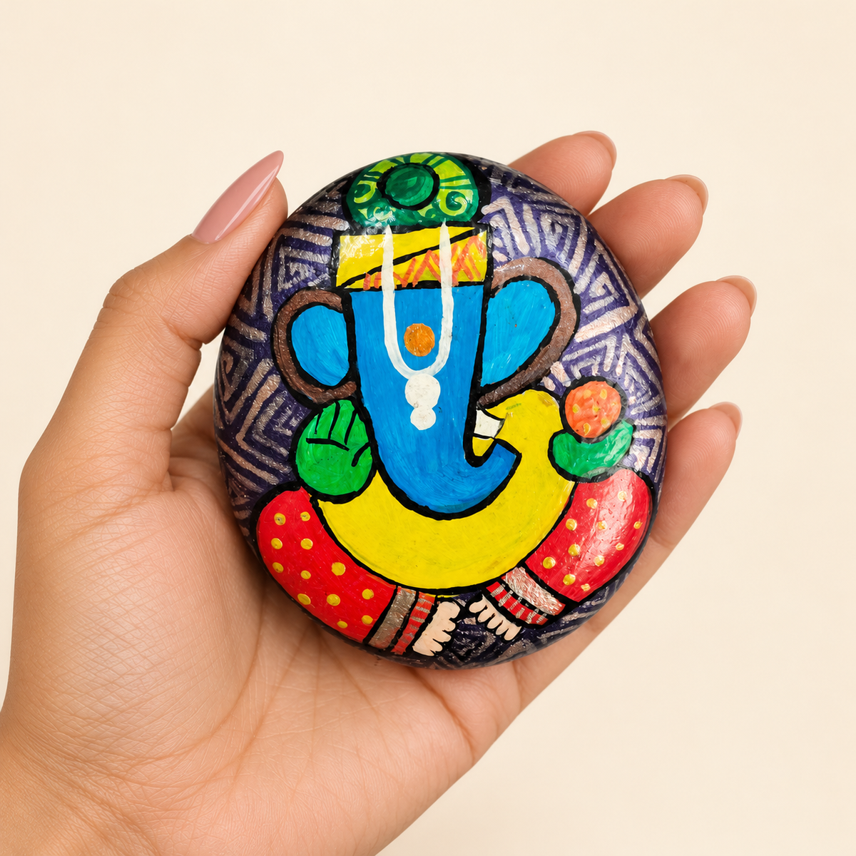 Ganesh: Azure Devotion hand-painted natural pebble art, shown in hand for scale