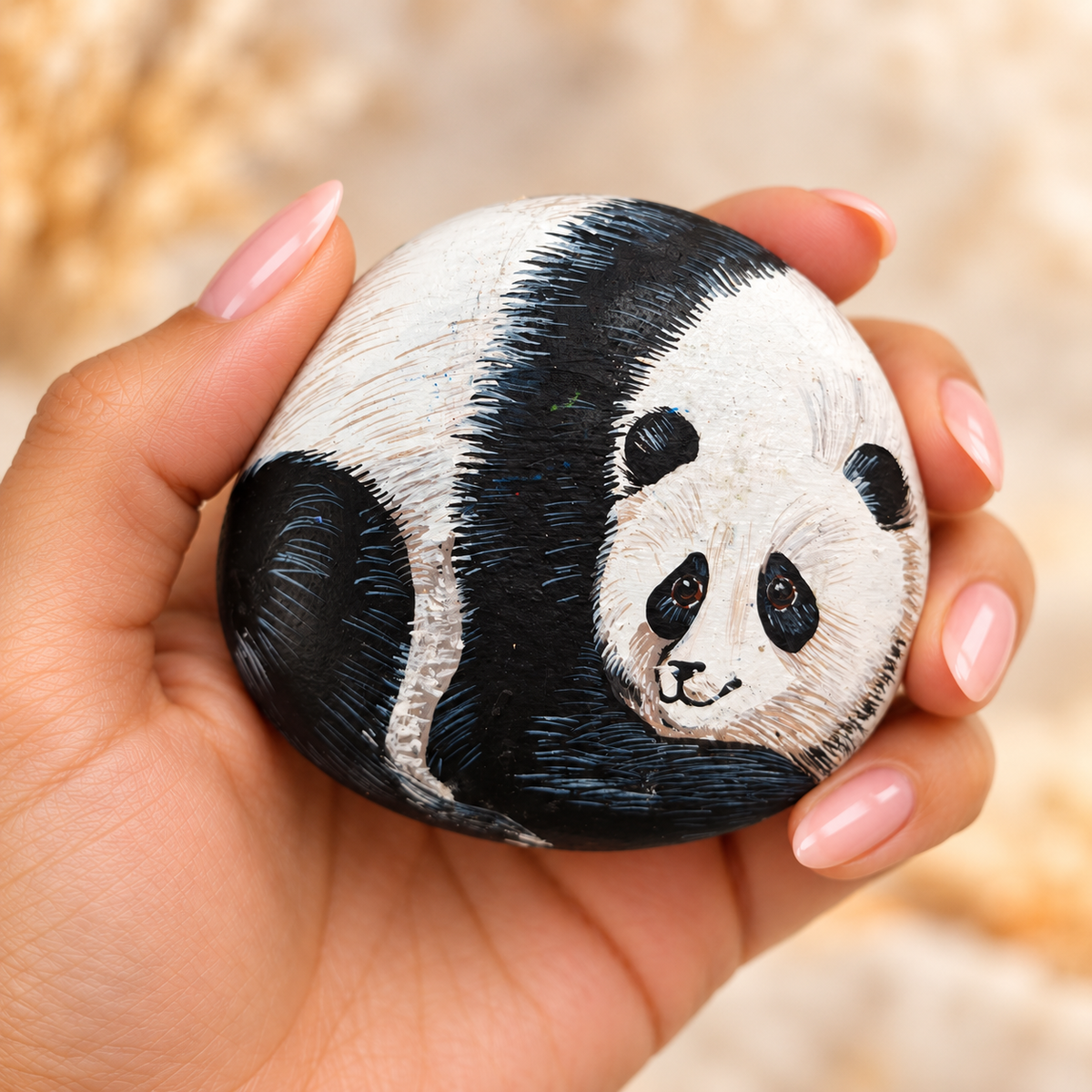 Panda Love: selected hand-painted pebble held in hand