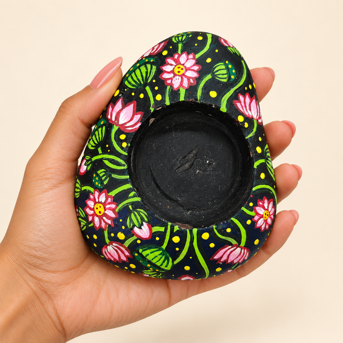 Night Bloom: Lotus Meadow hand-painted natural pebble tealight holder, shown in hand for scale