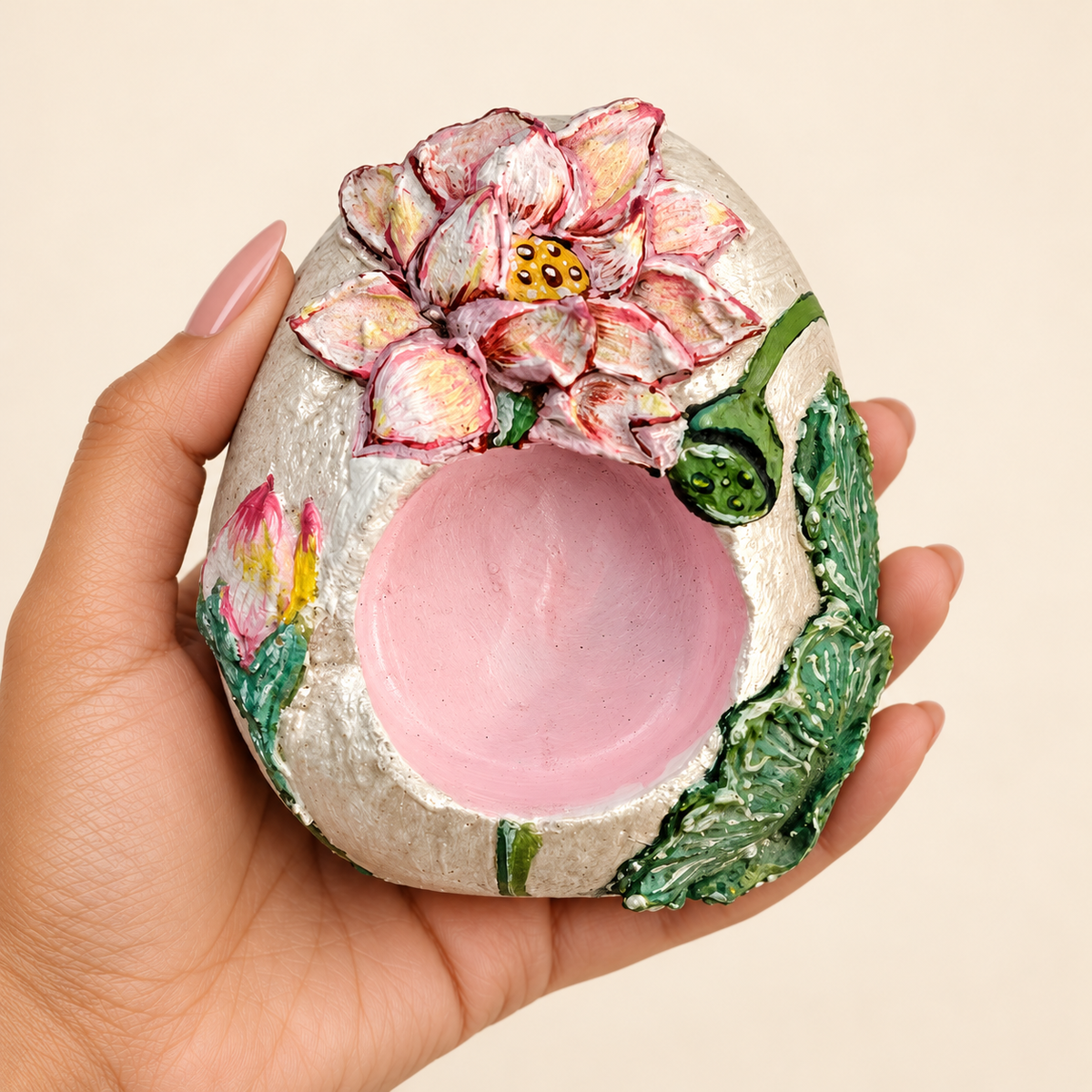 Sculpted Lotus: Blush Bloom hand-painted natural pebble tealight holder, shown in hand for scale