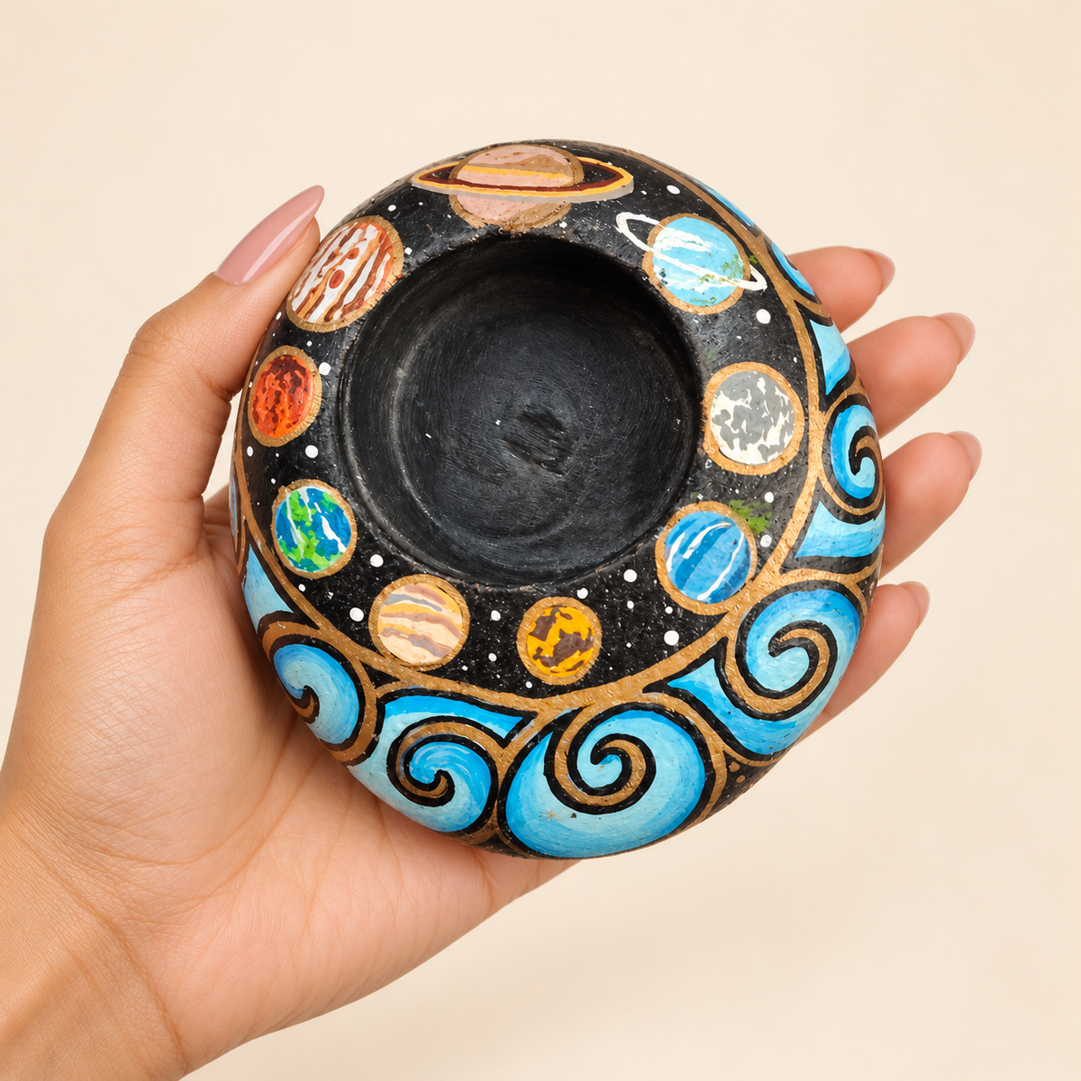 Cosmic Orbit: Planet Garden hand-painted natural pebble tealight holder, shown in hand for scale