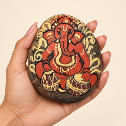 Ganesh: Rhythm of Blessings hand-painted natural pebble art, shown in hand for scale