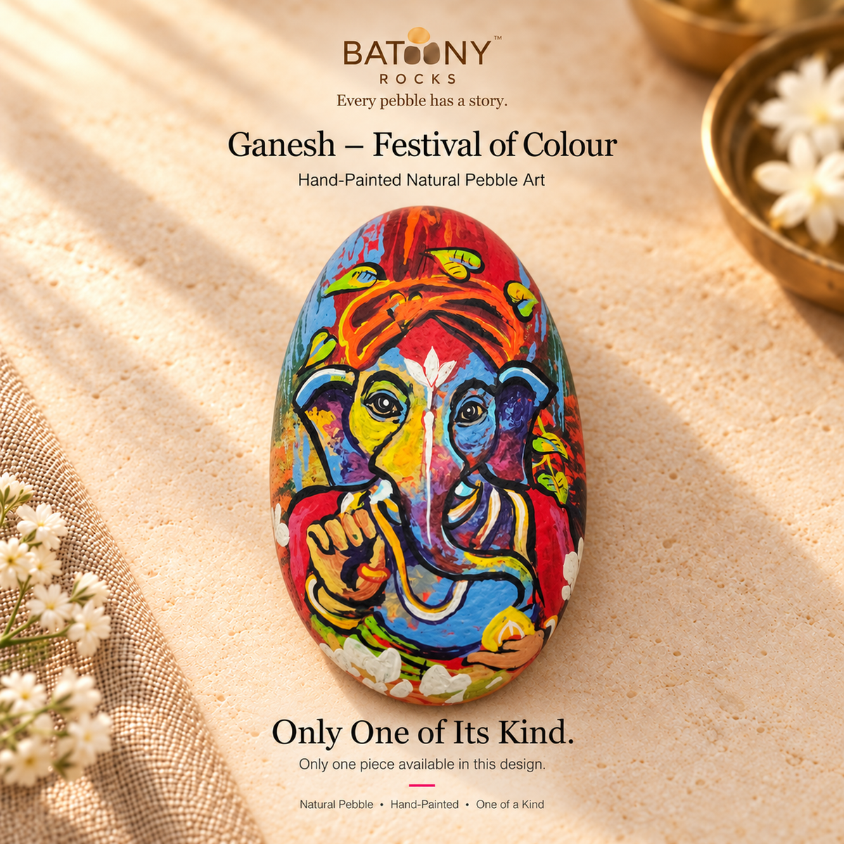 Ganesh: Festival of Colour hand-painted natural pebble art, on a warm stone surface