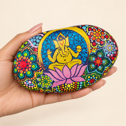 Ganesh: Garden of Abundance hand-painted natural pebble art, shown in hand for scale