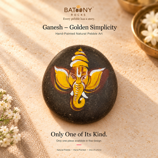 Ganesh: Golden Simplicity hand-painted natural pebble art, on a warm stone surface