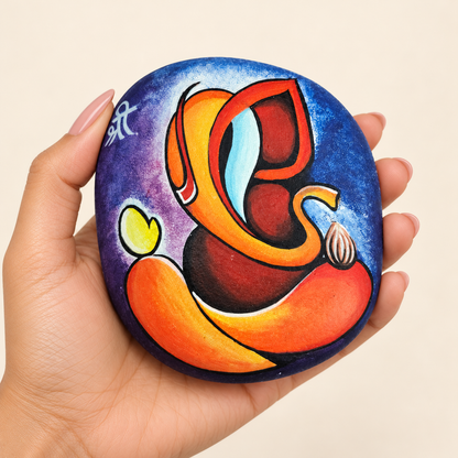 Ganesh: Sunset Harmony hand-painted natural pebble art, shown in hand for scale