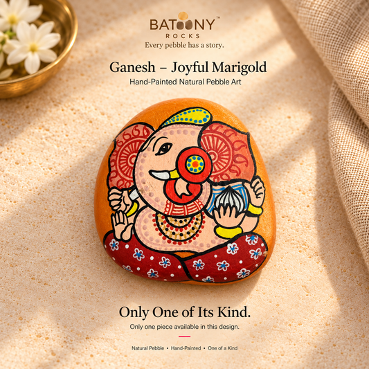 Ganesh: Joyful Marigold hand-painted natural pebble art, on a warm stone surface
