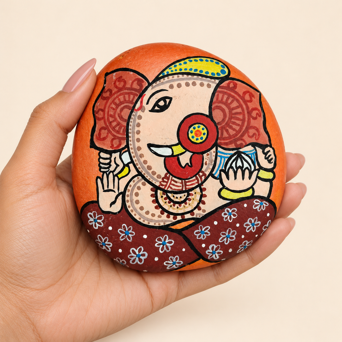 Ganesh: Warm Welcome hand-painted natural pebble art, shown in hand for scale