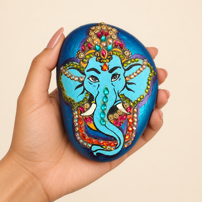Ganesh: Jewel of Blessings hand-painted natural pebble art, shown in hand for scale