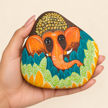 Ganesh: Leaf and Light hand-painted natural pebble art, shown in hand for scale