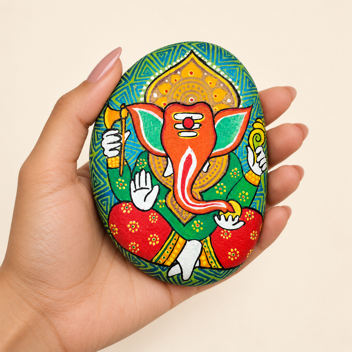 Ganesh: Emerald Temple hand-painted natural pebble art, shown in hand for scale