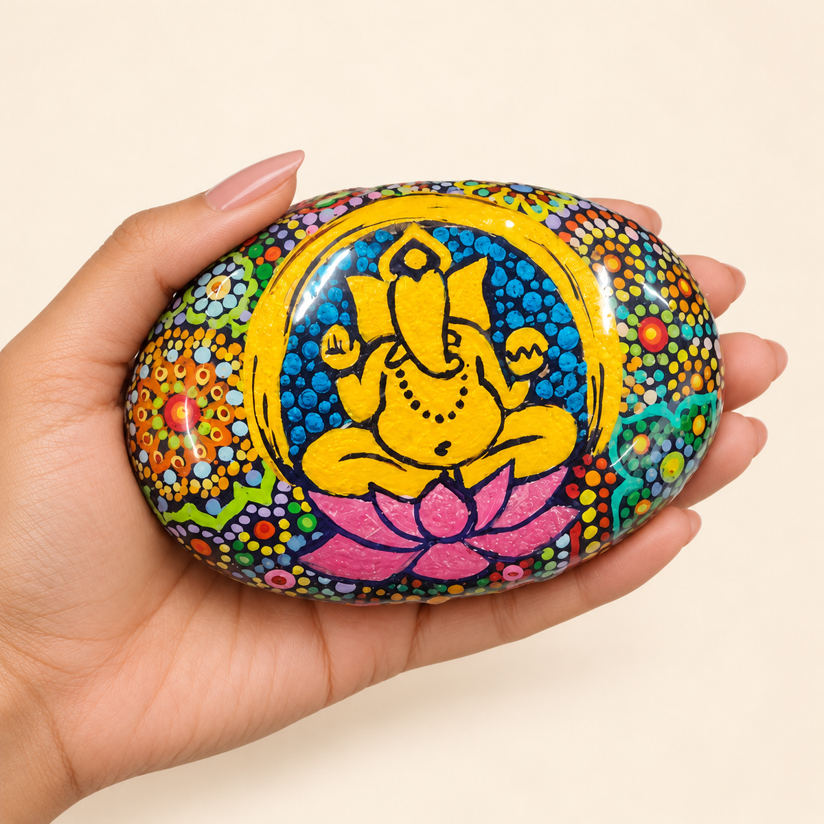 Ganesh: Golden Lotus hand-painted natural pebble art, shown in hand for scale