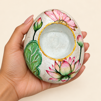 Ivory Lotus: Gentle Bloom hand-painted natural pebble tealight holder, shown in hand for scale