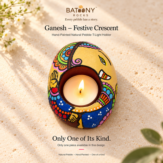 Ganesh: Festive Crescent hand-painted natural pebble tealight holder, on a warm stone surface