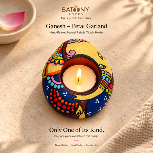 Ganesh: Petal Garland hand-painted natural pebble tealight holder, on a warm stone surface