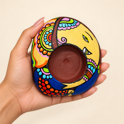 Ganesh: Marigold Grace hand-painted natural pebble tealight holder, shown in hand for scale