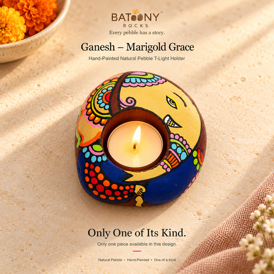 Ganesh: Marigold Grace hand-painted natural pebble tealight holder, on a warm stone surface