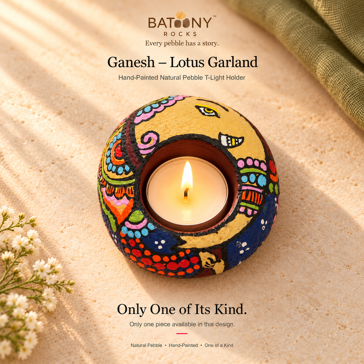 Ganesh: Lotus Garland hand-painted natural pebble tealight holder, on a warm stone surface