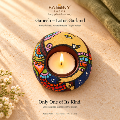 Ganesh: Lotus Garland hand-painted natural pebble tealight holder, on a warm stone surface