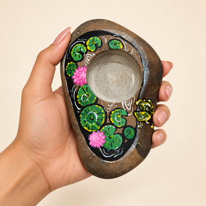 Lotus Pond: Earth and Bloom hand-painted natural pebble tealight holder, shown in hand for scale