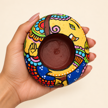 Ganesh: Festival Grace hand-painted natural pebble tealight holder, shown in hand for scale