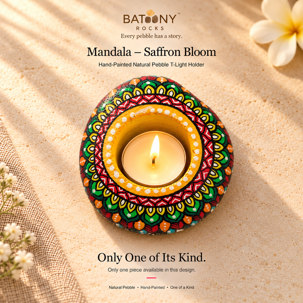 Mandala: Saffron Bloom hand-painted natural pebble tealight holder, on a warm stone surface