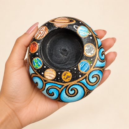 Cosmic Orbit: Planet Garden hand-painted natural pebble tealight holder, shown in hand for scale