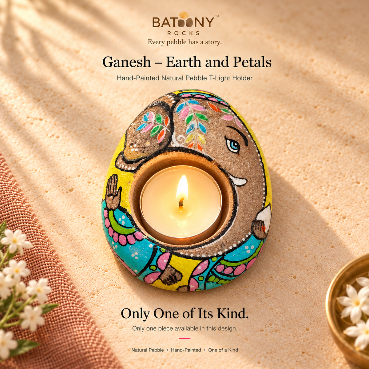 Ganesh: Earth and Petals hand-painted natural pebble tealight holder, on a warm stone surface