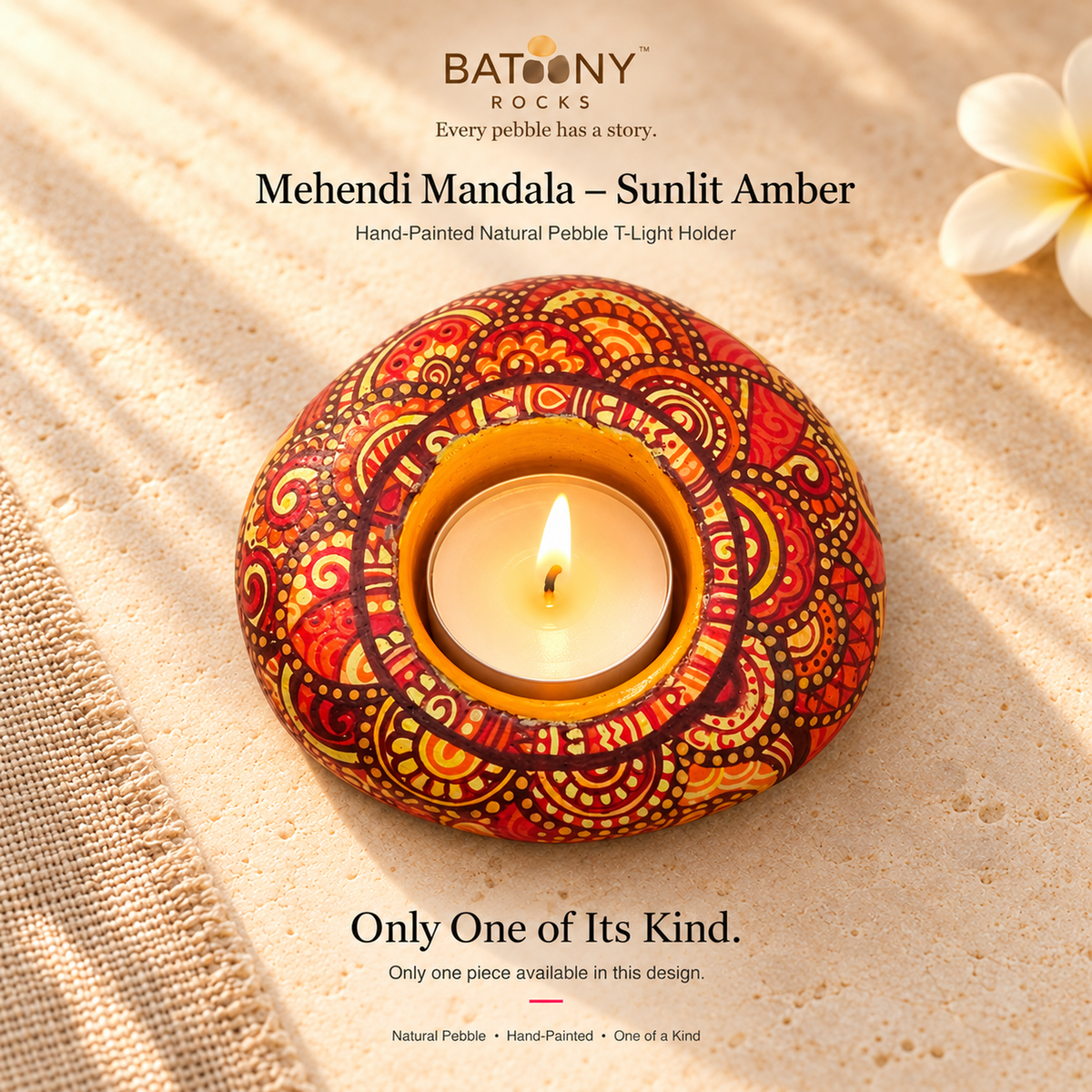 Mehendi Mandala: Sunlit Amber hand-painted natural pebble tealight holder, on a warm stone surface