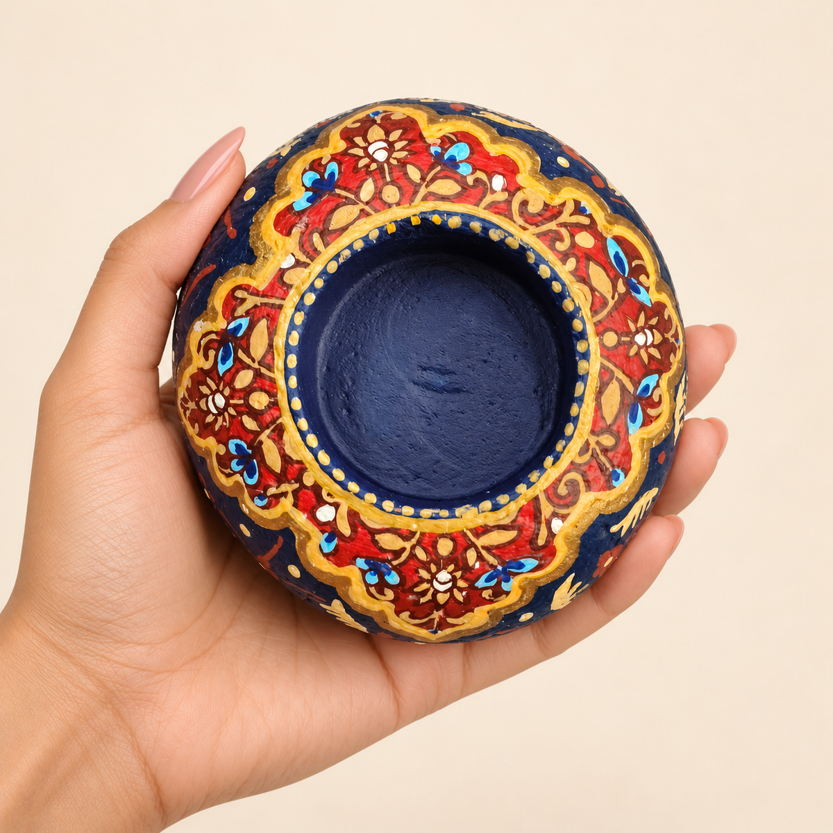 Royal Florals: Blue Reverie hand-painted natural pebble tealight holder, shown in hand for scale