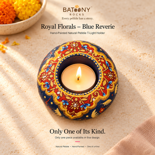 Royal Florals: Blue Reverie hand-painted natural pebble tealight holder, on a warm stone surface