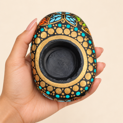Butterfly Mandala: Golden Turquoise hand-painted natural pebble tealight holder, shown in hand for scale