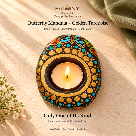 Butterfly Mandala: Golden Turquoise hand-painted natural pebble tealight holder, on a warm stone surface