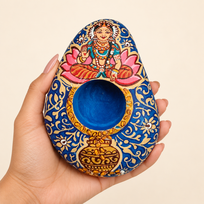 Lakshmi: Lotus Abundance hand-painted natural pebble tealight holder, shown in hand for scale