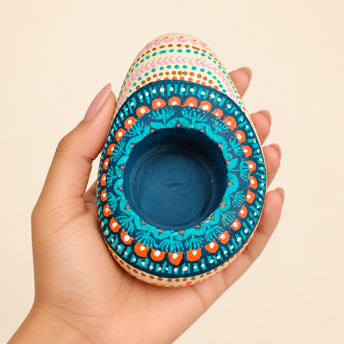 Peacock Fan: Lagoon Blue hand-painted natural pebble tealight holder, shown in hand for scale
