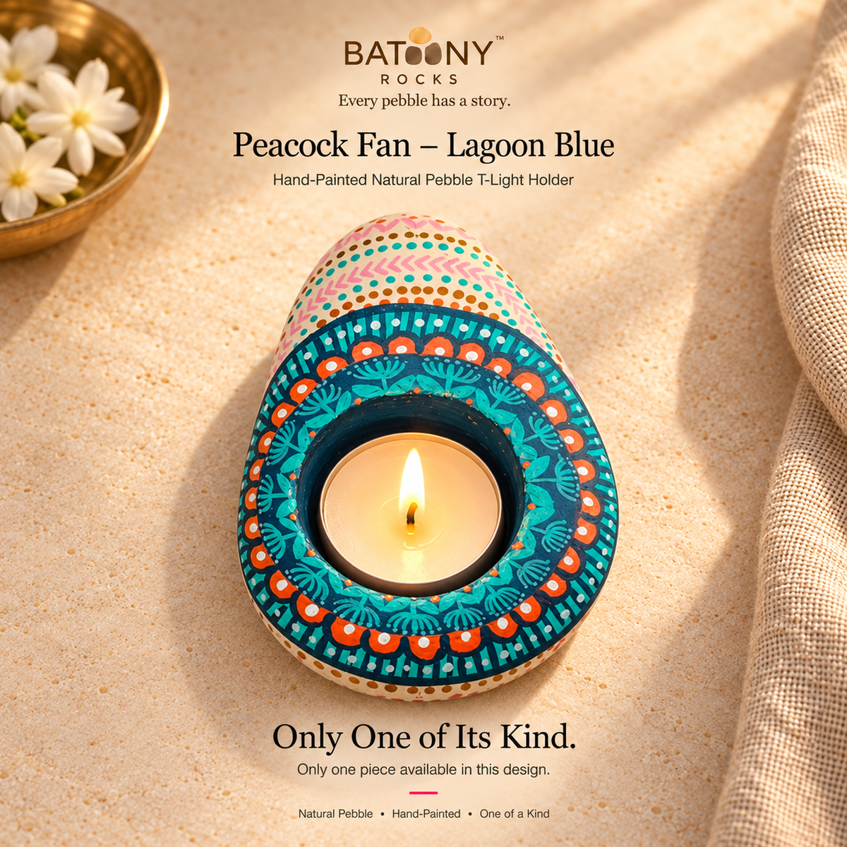 Peacock Fan: Lagoon Blue hand-painted natural pebble tealight holder, on a warm stone surface