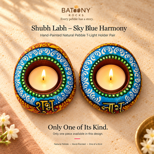 Shubh Labh: Sky Blue Harmony hand-painted natural pebble tealight holder, on a warm stone surface