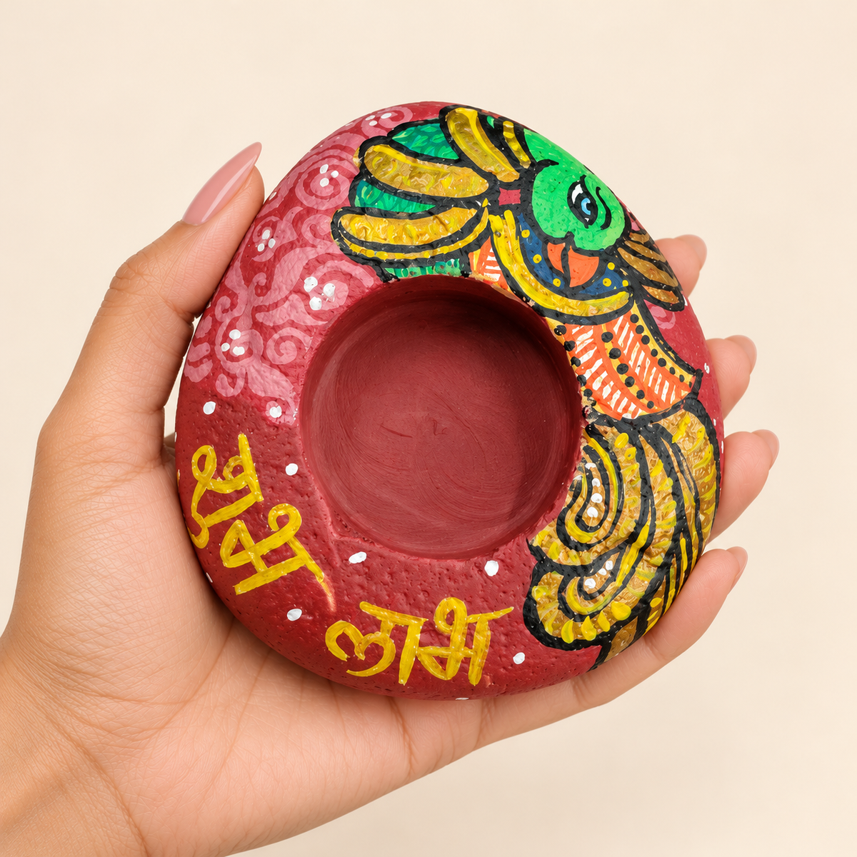 Parrot: Ruby Garden hand-painted natural pebble tealight holder, shown in hand for scale