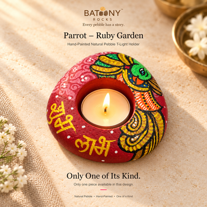 Parrot: Ruby Garden hand-painted natural pebble tealight holder, on a warm stone surface