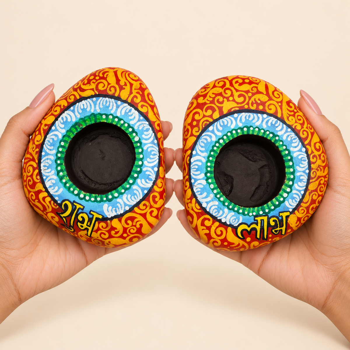 Shubh Labh: Sky Mandala hand-painted natural pebble tealight holder, shown in hand for scale