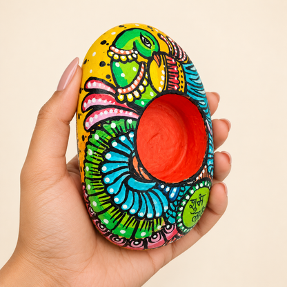 Parrot: Emerald Celebration hand-painted natural pebble tealight holder, shown in hand for scale