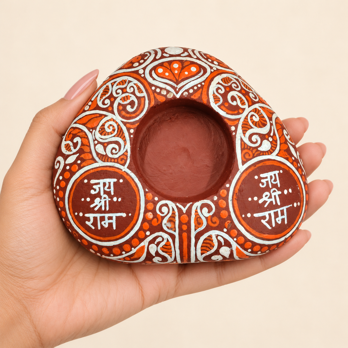 Jai Shri Ram: Terracotta Devotion hand-painted natural pebble tealight holder, shown in hand for scale