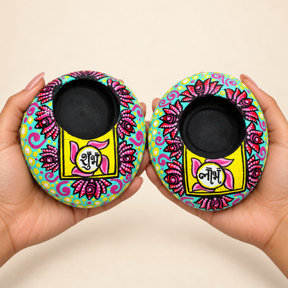 Shubh Labh: Midnight Bloom hand-painted natural pebble tealight holder, shown in hand for scale