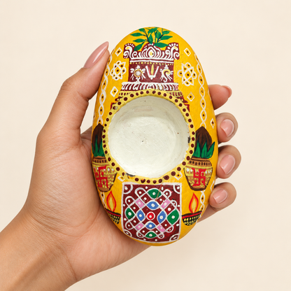 Golden Haveli: Folk Garden hand-painted natural pebble tealight holder, shown in hand for scale