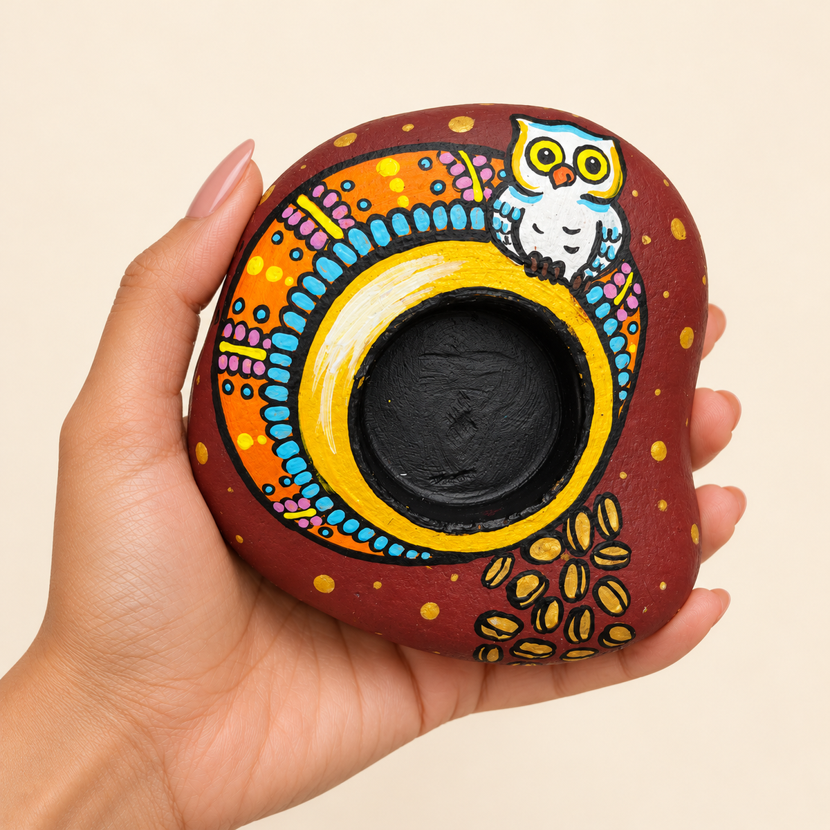 Wise Owl: Rainbow Arch hand-painted natural pebble tealight holder, shown in hand for scale