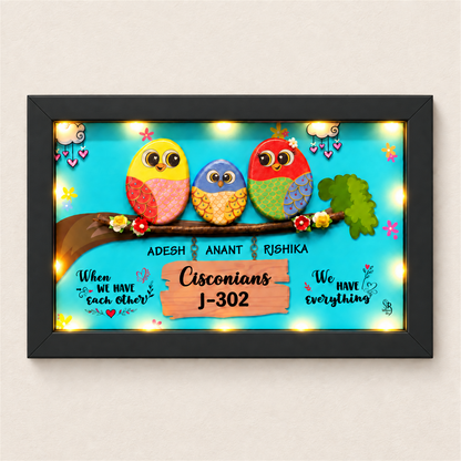 Celebrate Togetherness with Unique Family Pebble Art: three colourful birds in a family nameboard, black frame, on a beige background