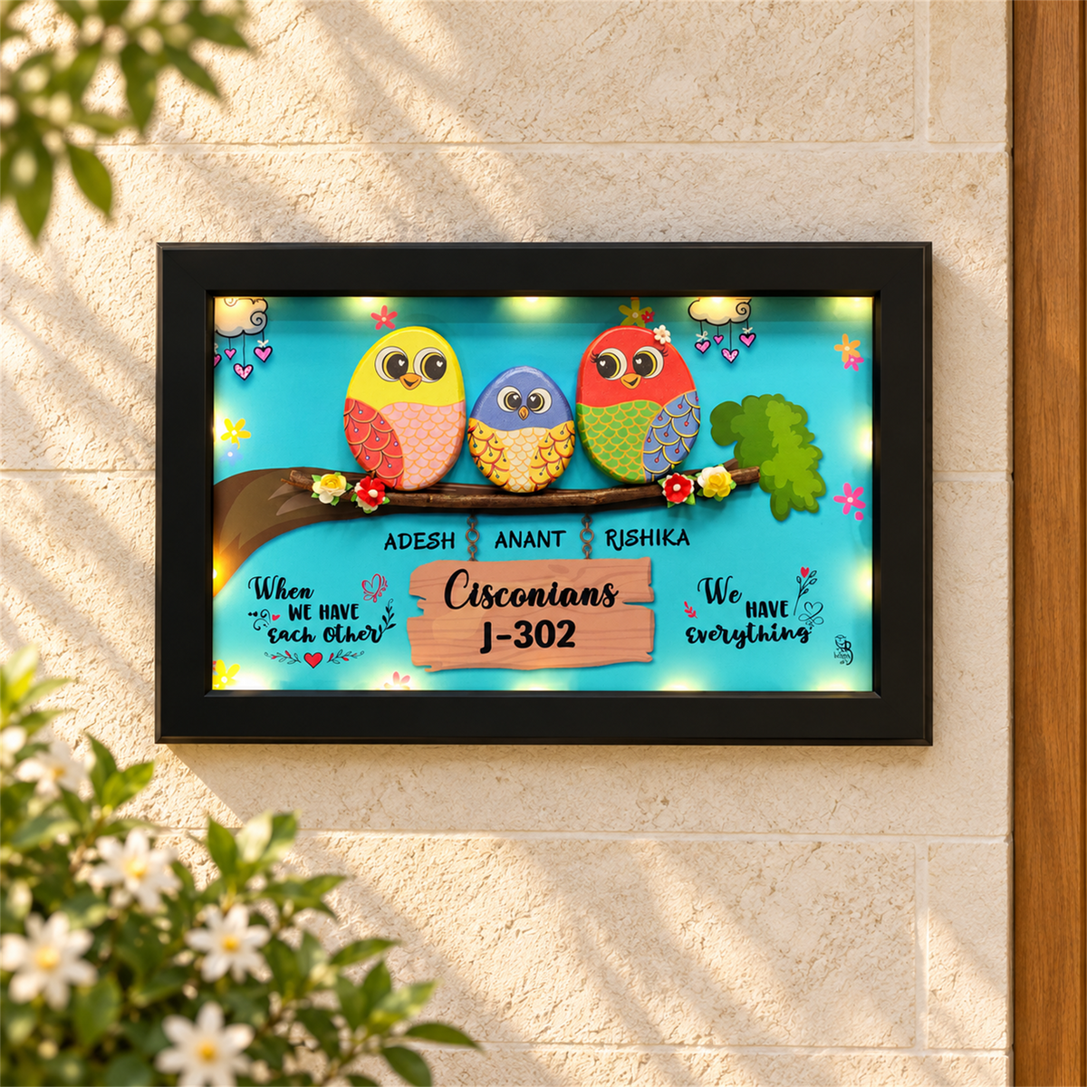 Celebrate Togetherness with Unique Family Pebble Art: three colourful birds in a family nameboard, black frame, in a home setting