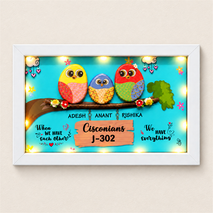 Celebrate Togetherness with Unique Family Pebble Art: three colourful birds in a family nameboard, white frame, on a beige background