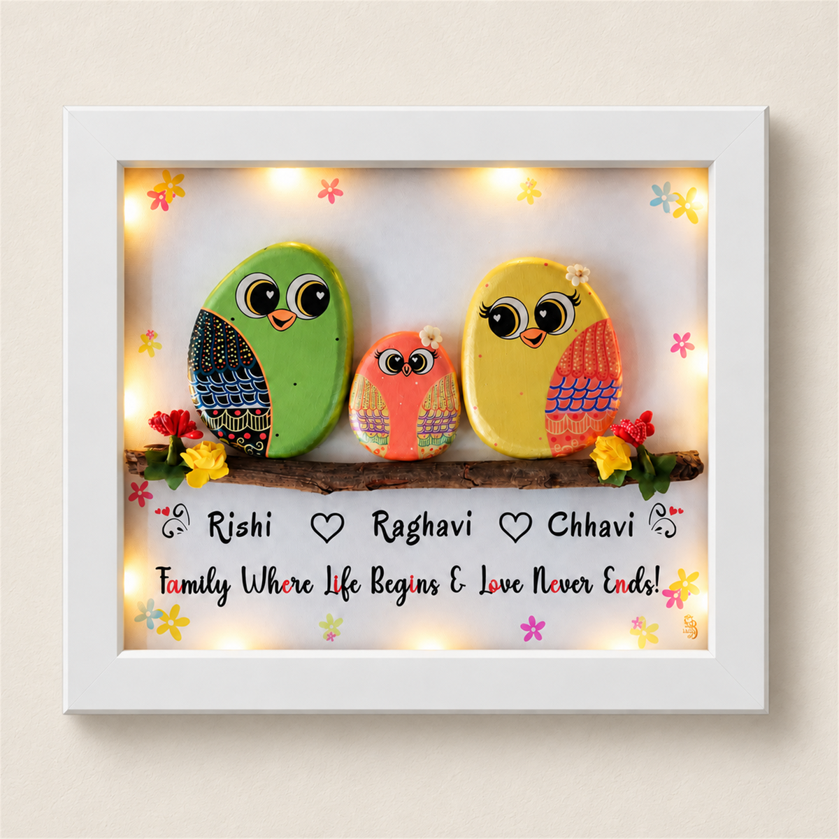 Happily Ever After Pebble Art: three colourful little birds on a flower-trimmed branch, white frame, on a beige background